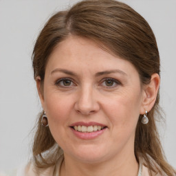 Joyful white adult female with long  brown hair and grey eyes