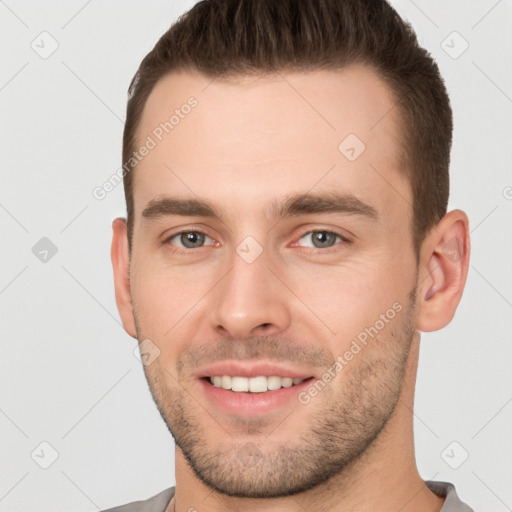 Joyful white young-adult male with short  brown hair and brown eyes