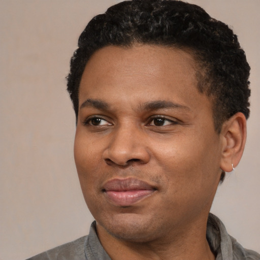 Joyful black adult male with short  black hair and brown eyes