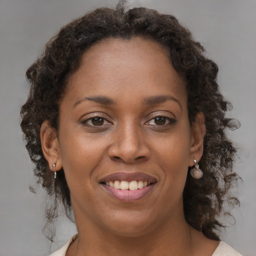 Joyful black young-adult female with medium  brown hair and brown eyes