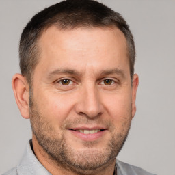 Joyful white adult male with short  brown hair and brown eyes