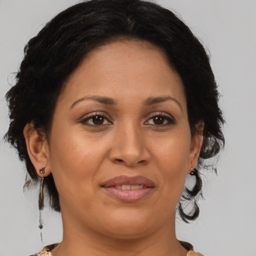 Joyful latino adult female with medium  brown hair and brown eyes