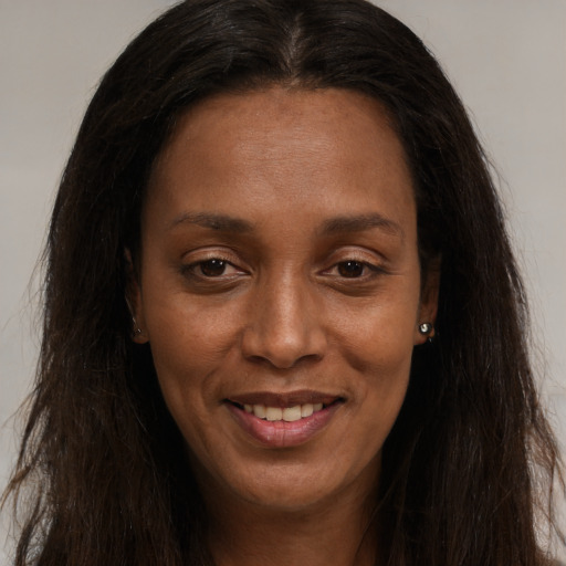 Joyful black young-adult female with long  brown hair and brown eyes