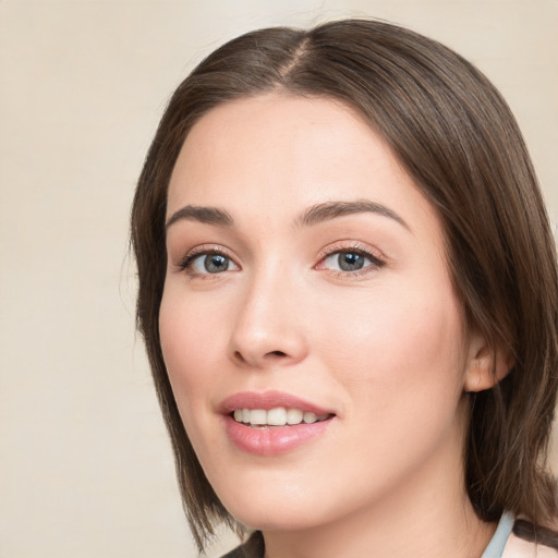 Joyful white young-adult female with medium  brown hair and green eyes