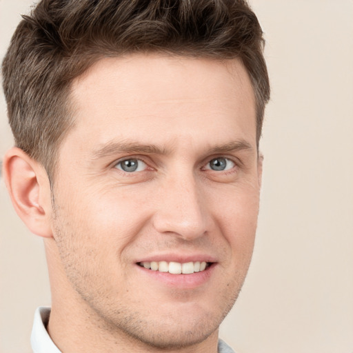 Joyful white young-adult male with short  brown hair and grey eyes