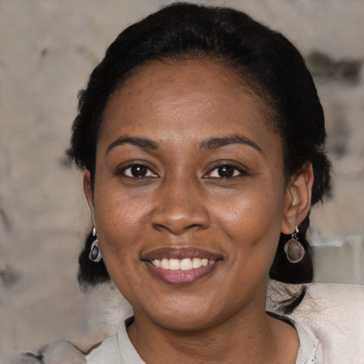 Joyful black adult female with short  black hair and brown eyes