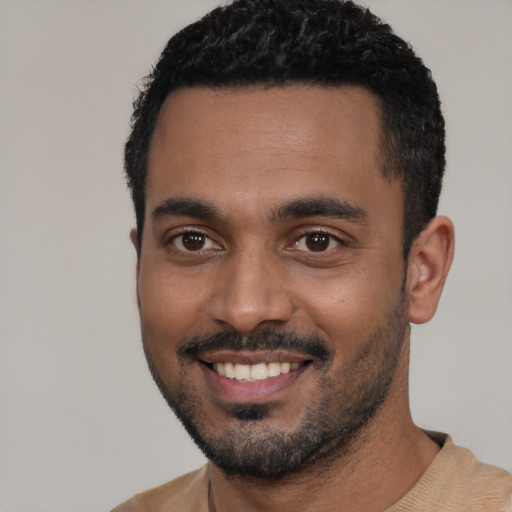 Joyful black young-adult male with short  black hair and brown eyes