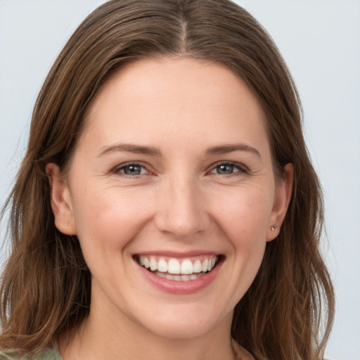 Joyful white young-adult female with long  brown hair and grey eyes