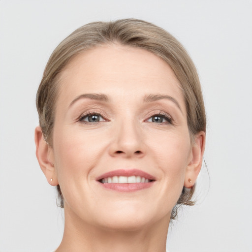 Joyful white adult female with medium  brown hair and grey eyes