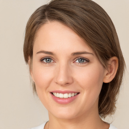 Joyful white young-adult female with medium  brown hair and green eyes