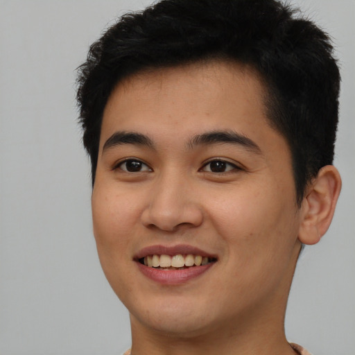 Joyful asian young-adult male with short  brown hair and brown eyes