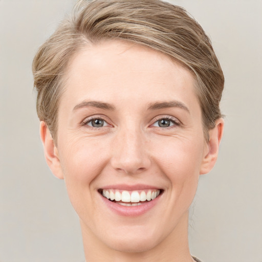 Joyful white young-adult female with short  brown hair and grey eyes