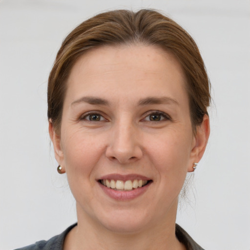 Joyful white young-adult female with short  brown hair and grey eyes