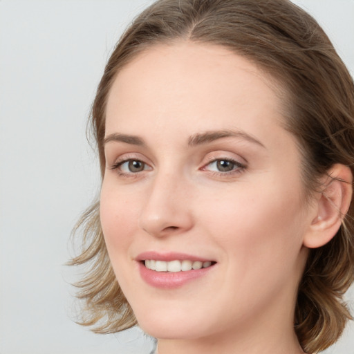 Joyful white young-adult female with long  brown hair and blue eyes