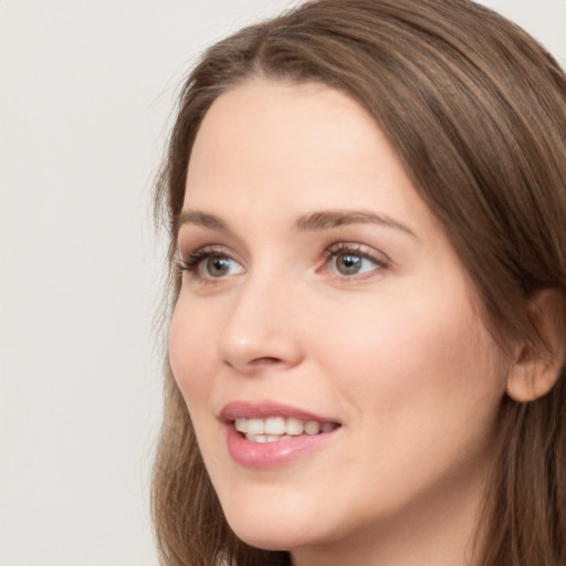 Joyful white young-adult female with long  brown hair and grey eyes