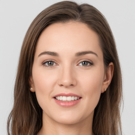 Joyful white young-adult female with long  brown hair and grey eyes