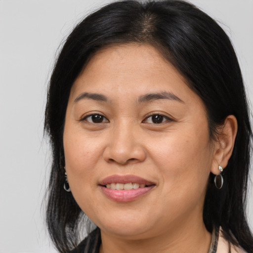 Joyful latino adult female with medium  brown hair and brown eyes