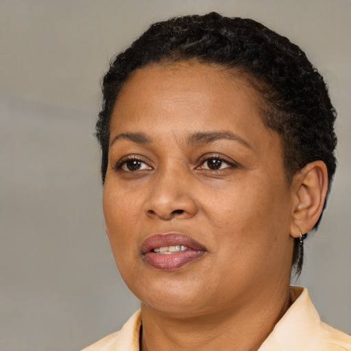 Joyful black adult female with short  black hair and brown eyes
