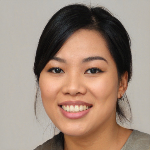 Joyful asian young-adult female with medium  black hair and brown eyes