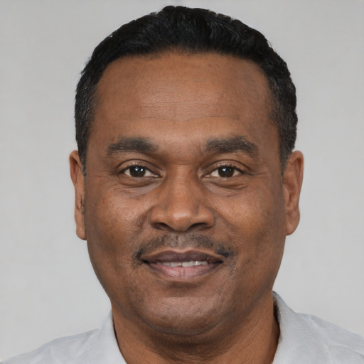 Joyful black adult male with short  black hair and brown eyes