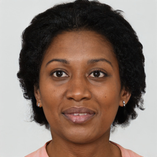 Joyful black adult female with short  black hair and brown eyes