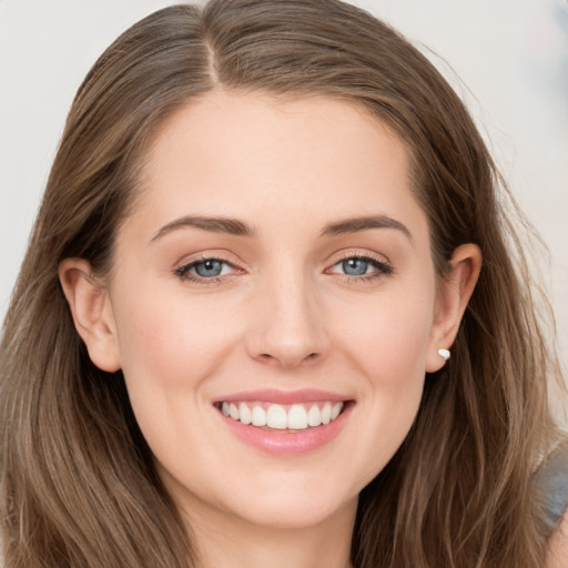 Joyful white young-adult female with long  brown hair and grey eyes