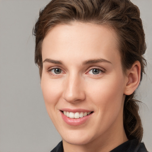 Joyful white young-adult female with medium  brown hair and grey eyes