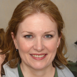 Joyful white adult female with medium  brown hair and blue eyes