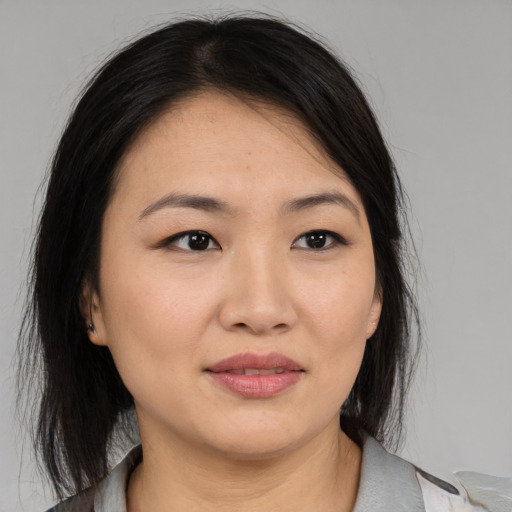 Joyful asian young-adult female with medium  brown hair and brown eyes