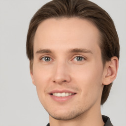 Joyful white young-adult male with short  brown hair and grey eyes