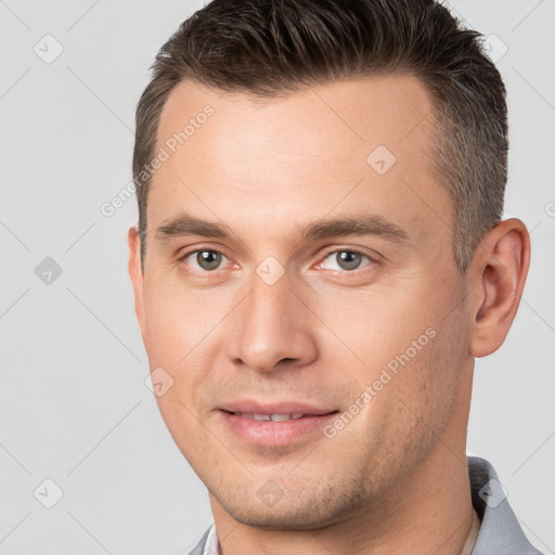 Joyful white young-adult male with short  brown hair and brown eyes