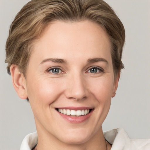 Joyful white young-adult female with short  brown hair and grey eyes