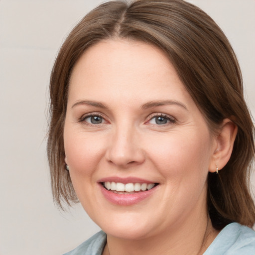 Joyful white young-adult female with medium  brown hair and blue eyes