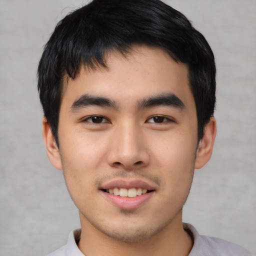 Joyful asian young-adult male with short  black hair and brown eyes