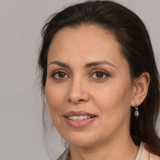 Joyful white adult female with long  brown hair and brown eyes