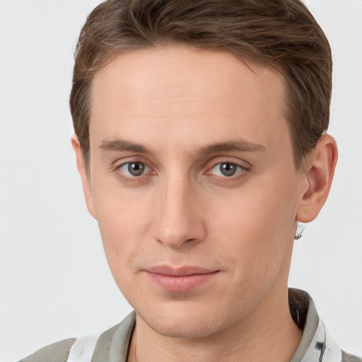 Joyful white young-adult male with short  brown hair and grey eyes