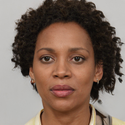 Joyful black adult female with short  brown hair and brown eyes