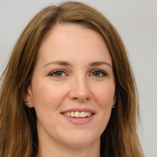 Joyful white young-adult female with long  brown hair and green eyes