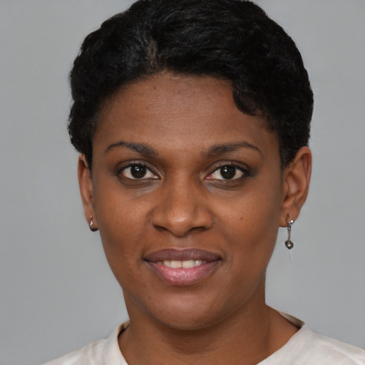 Joyful black young-adult female with short  black hair and brown eyes