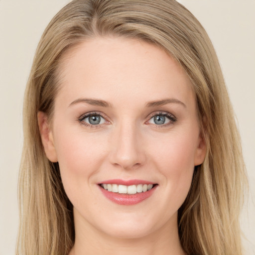 Joyful white young-adult female with long  brown hair and blue eyes