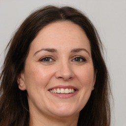 Joyful white adult female with long  brown hair and grey eyes