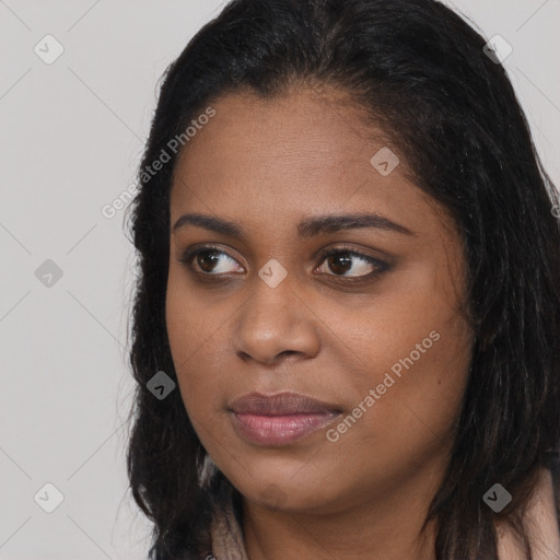 Joyful black young-adult female with long  black hair and brown eyes