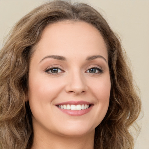 Joyful white young-adult female with long  brown hair and green eyes