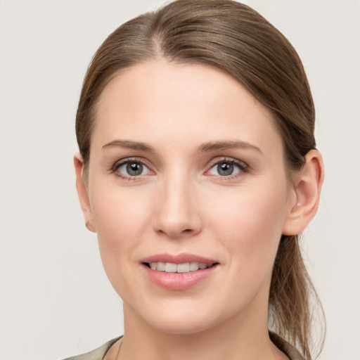 Joyful white young-adult female with long  brown hair and grey eyes