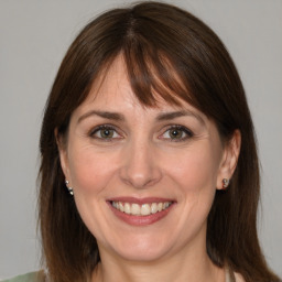 Joyful white adult female with medium  brown hair and grey eyes