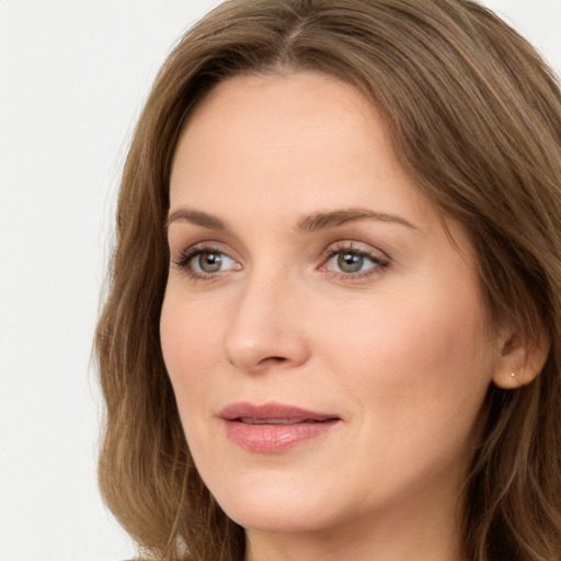 Joyful white young-adult female with long  brown hair and green eyes