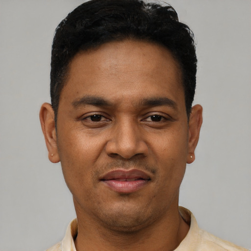 Joyful latino young-adult male with short  black hair and brown eyes