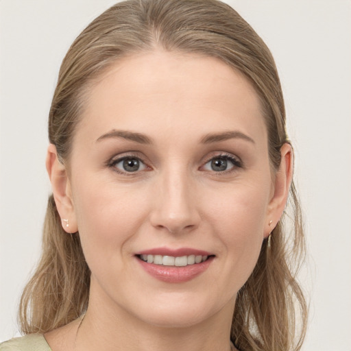 Joyful white young-adult female with medium  brown hair and grey eyes