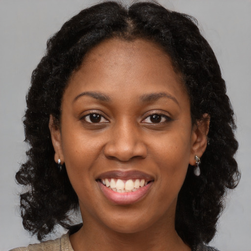 Joyful black young-adult female with medium  brown hair and brown eyes