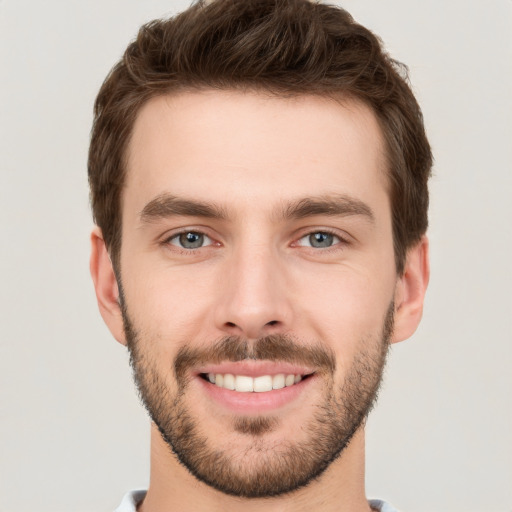 Joyful white young-adult male with short  brown hair and grey eyes